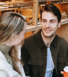 man and woman talking outside a bakery