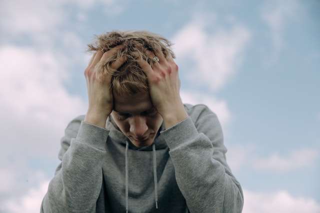 man with head in hands looking down