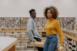 man-and-woman-standing-a-few-feet-apart-in-a-library-setting